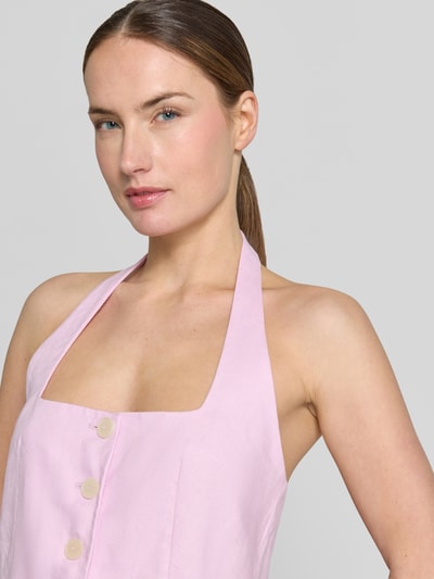 Frauenmodel trägt Weste aus Leinen mit Neckholder Modell 'BORELI' von Mango in zartem Rosa, Knopfleiste, Karree-Ausschnitt, taillierter Schnitt, Nahaufnahme Oberkörper.