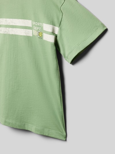 Jongen draagt Regular Fit T-shirt uit puur katoen van s.Oliver RED LABEL, look: effen kleuren, motiefprint en opschrift, ronde hals, korte mouw, detailopname rechterbovenkant.
