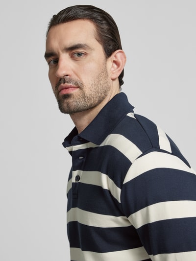 Mężczyzna nosi Relaxed Fit Poloshirt mit Streifenmuster von Lindbergh, mieszanka bawełny, wzór w paski, kołnierzyk polo, listwa guzikowa, długość tyłu w rozmiarze M 71 cm, zbliżenie na górną część ciała