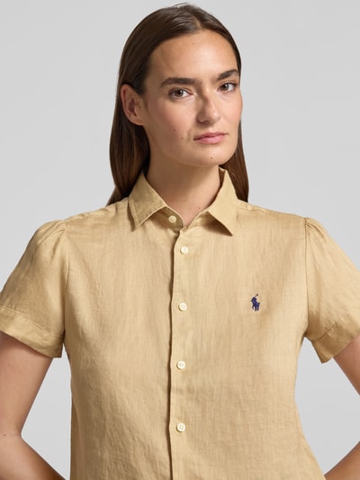 Frauenmodel trägt Regular Fit Leinenbluse aus reinem Leinen von Polo Ralph Lauren, Optik: Unifarben, Materialverarbeitung: Flammgarn, Logo-Stitching, Hemdkragen, V-Ausschnitt, Knopfleiste, Ärmelform: Kurzarm, Nahaufnahme Oberkörper.