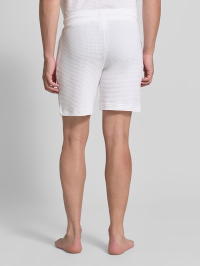 Männermodel trägt Regular Fit Sweatshorts aus Baumwoll-Mix Modell 'AUSTIN' von HUGO in Weiß, strukturierte Oberfläche, Herren Sweatshorts, Ganzkörperansicht Rückansicht.