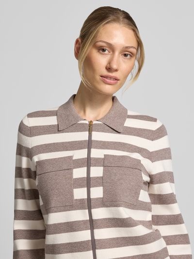Vrouwenmodel draagt gebreid jack uit Viscosemix van Christian Berg Woman met platte kraag, borstzakken, tweewegritssluiting, context: Dames gebreid jack, viscosemix, los model, platte kraag, tweewegritssluiting, opgestikte borstzakken, ruglengte maat S 52 cm, mouwlengte maat S 60 cm. Nahaufnahme Oberkörper.
