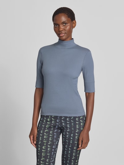 Frauenmodel trägt Slim Fit T-Shirt aus Baumwoll-Mix mit Stehkragen von Marc Cain in Blau, halblanger Arm, elastisch, Ganzkörperansicht von vorne.