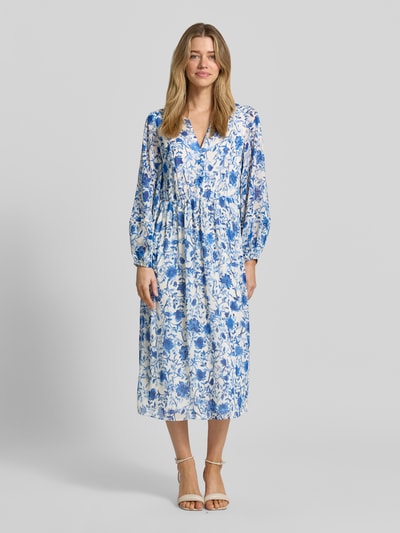 Frauenmodel trägt Midikleid aus reiner Viskose mit floralem Allover-Print von ROBE LÉGÈRE, Tailliert, Tunika-Ausschnitt, Langärmelig, Knopfleiste, Rückenlänge bei Größe 36: 123 cm, Brustweite 49 cm, Ärmellänge 60 cm, Farbmix aus Blau und Weiß, fließende Textur, Ganzkörperansicht von vorne.