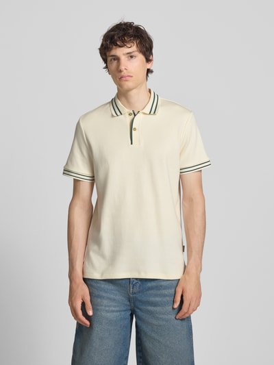 Männermodel trägt Slim Fit Poloshirt mit Strukturmuster Modell 'FABLE' von Blend in Creme mit grünen Streifen, Nahaufnahme Oberkörper. Reine Baumwolle, Knopfleiste, Rückenlänge 69 cm bei Größe M.