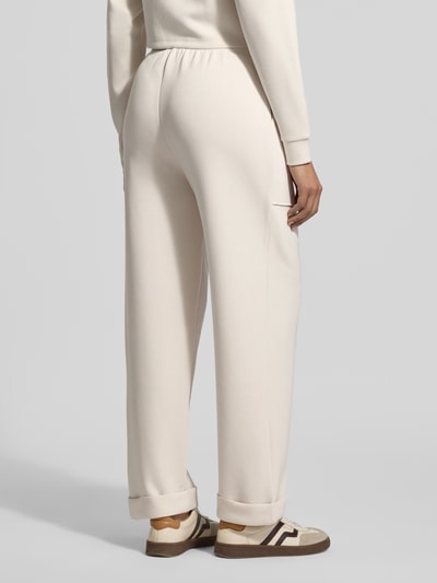 Frauenmodel trägt Sweatpants mit Eingrifftaschen und Aufschlag von Christian Berg Woman, Material-Mix mit Modal-Mix, Relaxed-Fit, Ganzkörperansicht Rückansicht.