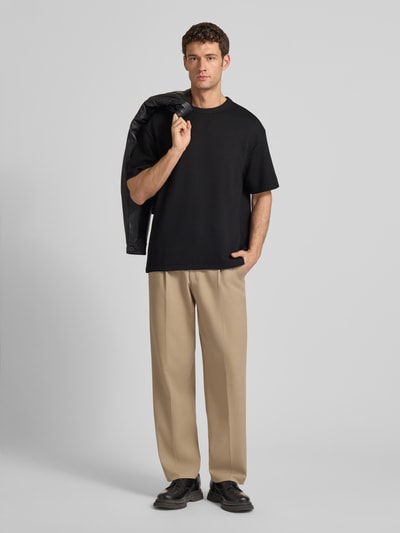 Männermodel trägt schwarzes T-Shirt mit Strukturmuster, Relaxed Fit, Rundhalsausschnitt, Modell 'CRINKLE CREPE SPACER' von CK Calvin Klein, Ganzkörperansicht von vorne.