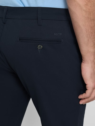 Männermodel trägt Slim Fit Hose mit Gesäßtaschen von MCNEAL in Dunkelblau, glatte Textur, Detailaufnahme Rückansicht, Herren HOSE. Kontext: Knopf- und Reißverschluss, Eingrifftaschen, Bundweite ca. 45 cm in Größe M, Innenbeinlänge ca. 82 cm.