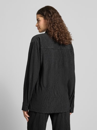 Frauenmodel trägt Relaxed Fit Bluse mit Strukturmuster von REVIEW aus Material-Mix mit Stretch-Anteil, Rückenlänge 62 cm, Ärmellänge 57 cm, Ganzkörperansicht Rückansicht.