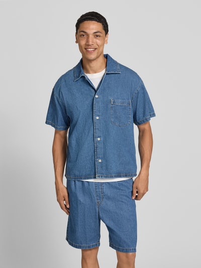Männermodel trägt Modern Fit jeanshemd met borstzak model 'AUSTIN' van Jack & Jones, pure gewaxte katoen, kentkraag, knoopsluiting, ruglengte 66 cm, schouderbreedte 55 cm, mouwlengte 22 cm, blauw, structuur zichtbaar, eenvoudige vormen, ganzekörperansicht van voren
