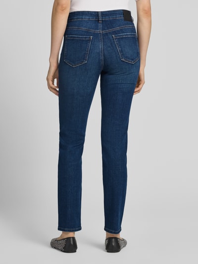 Frauenmodel trägt Skinny Fit Jeans aus elastischem Baumwoll-Mix mit Strasssteinen von Marc Cain in Dunkelblau, 5-Pocket-Design, Ganzkörperansicht Rückansicht.