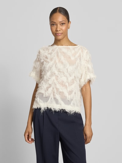 Kobiece model prezentuje bluzkę Relaxed Fit Bluse mit Fransen Modell 'MYLINE' od Selected Femme, efekt: jednolity kolor, frędzle, półprzezroczyste obszycie, dekolt w łódkę, krótki rękaw, fason: krój relaxed fit; całkowity widok z przodu.