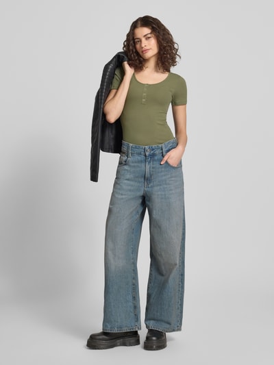 Vrouwenmodel draagt Slim Fit T-Shirt uit katoenmix model 'KITTE' van Pieces, olijfgroen, ribstructuur, korte mouw, unicolor, Henley, u-boothals, volledige lichaamsaanzicht van voren