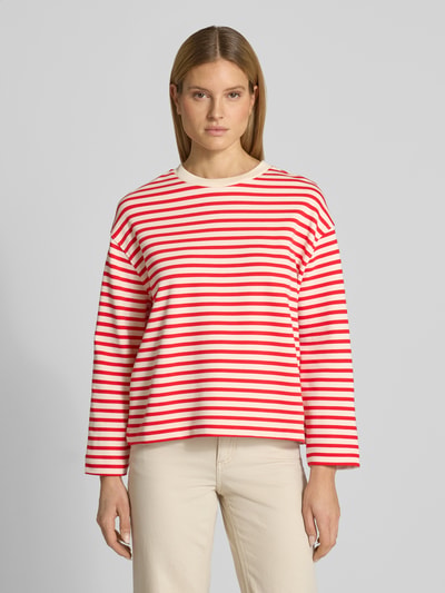 Kobiece model nosi bluzę Oversized Sweatshirt aus reiner Baumwolle Modell 'FRANKAA MAARLEN STRIPE' od armedangels, efekt: dwukolorowy, krój oversized, z napisem z logo, okrągły dekolt, długi rękaw, drobne prążkowanie, bawełna, jasne i czerwone pasy, przód na wysokości klatki piersiowej, zdjęcie: całkowity przód górnej części ciała.