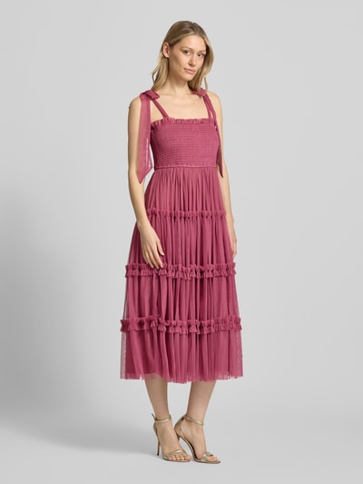 Frauenmodel trägt Knielanges Cocktailkleid mit Smok-Details von LACE & BEADS, Mesh, A-Linie, Stufen-Look, Schnürung, Ganzkörperansicht von vorne.