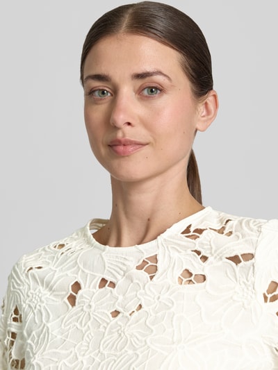 Modelka kobieca nosi Bluse mit Spitze und Rundhalsausschnitt od Oui, biała bawełna, koronka, prosty krój, zbliżenie na górną część ciała.