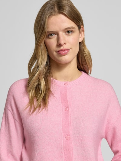 Frauenmodel trägt Strickjacke mit Rundhalsausschnitt Modell 'NATALIE' von JJXX, Regular Fit, Knopfleiste, rosa, Nahaufnahme Oberkörper.