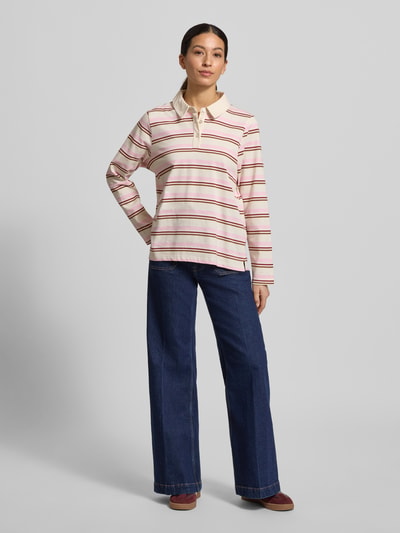 Frauenmodel trägt Poloshirt aus reiner Baumwolle von Soyaconcept in Creme mit roten und beigen Streifen, gerader Schnitt, Ganzkörperansicht von vorne