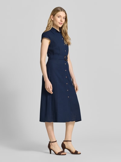 Frauenmodel trägt Hemdblusenkleid aus Viskose-Leinen-Mix mit Gürtel von Apricot in Dunkelblau, taillierter Schnitt, Midikleid, Knopfleiste, Hemdblusenkragen, Ganzkörperansicht von vorne.