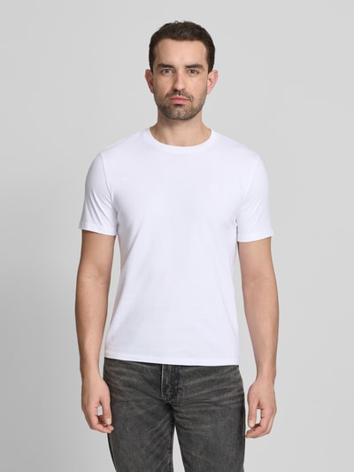 Männermodel trägt T-Shirt mit Label-Stitching und Rundhalsausschnitt von Scotch & Soda in Weiß, Reine Baumwolle, Regular-Fit, Ganzkörperansicht von vorne. Rückenlänge bei Größe M: 68 cm.
