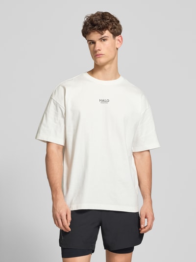 Männermodel trägt Boxy Fit T-Shirt mit Label-Print von ELITE, reine Baumwolle, Rundhalsausschnitt, Ganzkörperansicht von vorne.