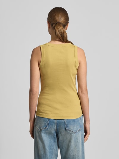 Frauenmodel trägt Drykorn Tanktop in Ripp-Optik Modell 'OLINA' aus reiner Baumwolle, Slim-Fit, gelb, Rundhalsausschnitt, Ganzkörperansicht Rückansicht.
