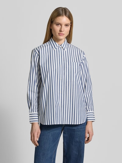 Vrouwenmodel draagt Loose Fit Hemdbluse aus reiner Baumwolle van Tommy Hilfiger, look: all-over motief, gestreept patroon, borstzak, lange mouw met manchet, gestikt logo, knoopsluiting, ronde rompzoom, fijne geweven structuur, puur katoen, vooraanzicht volledige lichaamsopname.