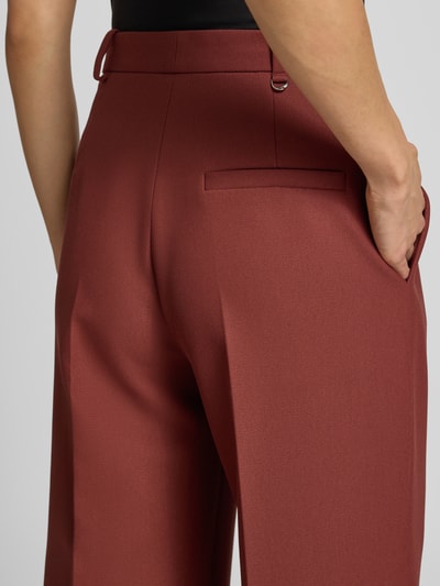 Männermodel trägt Weite Hose mit Viskose-Anteil Modell 'Hasmina' von HUGO, Damen Weite Hose, ceglany kolor, gładka faktura, detailaufnahme Rückansicht.
