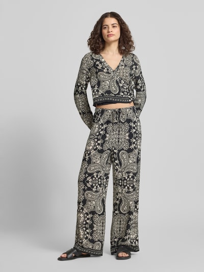 Frauenmodel trägt Loose Fit Weite Hose aus reiner Viskose Modell 'EMZA AJA' von Only, florales Allover-Muster, Popeline, Ganzkörperansicht von vorne.