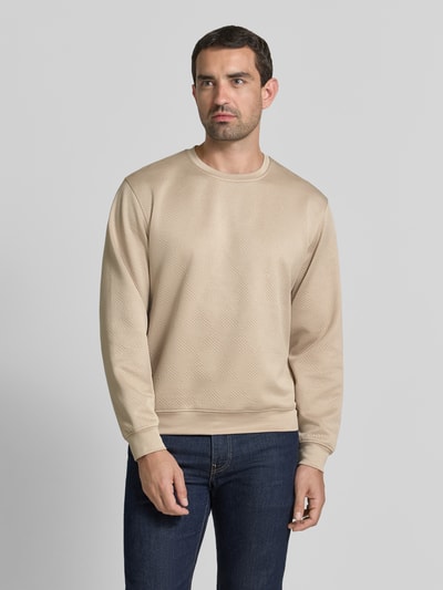 Männermodel trägt Sweatshirt im Allover-Look mit Rundhalsausschnitt von GUESS, beige Farbe, reine Baumwolle, Regular Fit, Ganzkörperansicht von vorne.