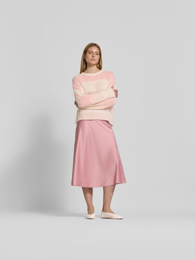Frauenmodel trägt Relaxed Fit Pullover mit Alpaka-Anteil von Juvia in Strick-Optik, Lochmuster, hellrosa, kombinierter Material-Mix, Ganzkörperansicht von vorne.