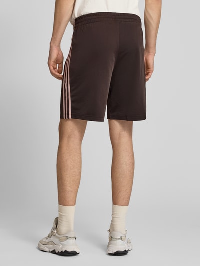 Männermodel trägt Regular Fit Sport-Shorts mit Kontraststreifen Modell 'FIREBIRD' von adidas Originals, Optik: Unifarben, Ganzkörperansicht Rückansicht