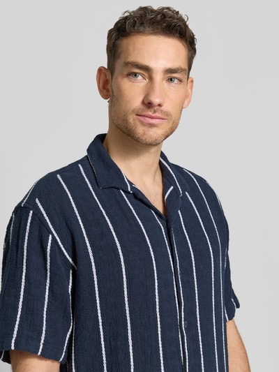 Männermodel trägt Regular Fit Freizeithemd mit Streifenmuster von MCNEAL aus Reiner Bio-Baumwolle, Reverskragen, Knopfleiste, Nahaufnahme Oberkörper.