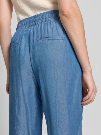 Frauenmodel trägt Wide Fit Stoffhose aus reinem Lyocell in Denim-Optik von Soyaconcept, Tunnelzug, elastischer Bund, Detailaufnahme Rückansicht. Damen Stoffhose, verkürzte Passform, Bundweite 37 cm, Innenbeinlänge 63 cm, glatte Oberfläche, hellblaue Farbe.