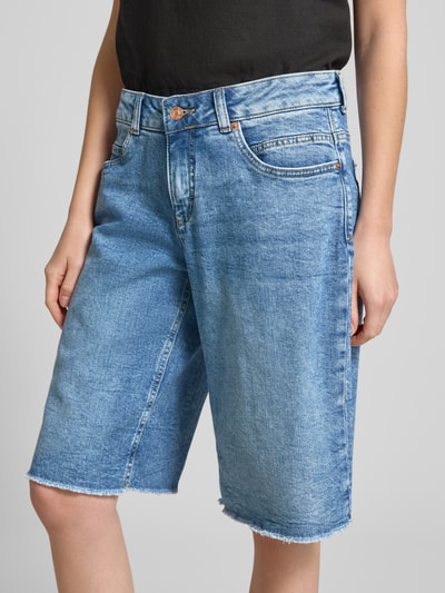 Frauenmodel trägt Jeansshorts mit Fransen Modell 'Rich' von MAC, Relaxed Fit, Baumwoll-Elasthan-Mix, Eingrifftaschen, Nahaufnahme Oberkörper.