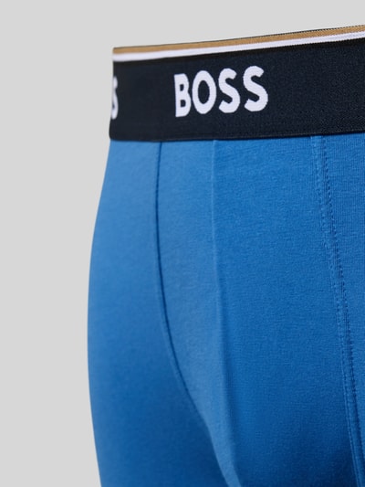 Männermodel trägt Obcisłe bokserki Model 'BOXER' od BOSS, efekt: jednolity kolor, z napisem z logo, paski w kontrastowym kolorze, mieszanka bawełny, wielopak: 3 szt., detal zbliżenie na biodra