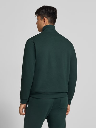 Männermodel trägt Regular Fit Sweatshirt mit Baumwoll-Anteil Modell 'Bradley' von JACK & JONES in Dunkelgrün, Rückenansicht, Material-Mix.