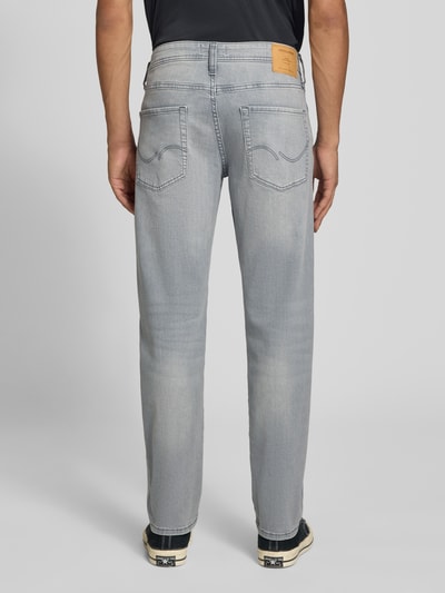 Męski model nosi Straight Fit Jeans mit Stretch-Anteil Modell 'MIKE' von JACK & JONES, mieszanka bawełny i elastanu, 5 kieszeni, szare, zapięcie na guzik i zamek błyskawiczny, szerokość w rozmiarze 32/32: 44 cm, długość wewnętrzna nogawki w rozmiarze 32/32: 78 cm, widok całej sylwetki z tyłu