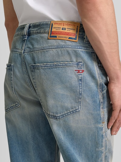 Männermodel trägt Relaxed Fit Jeans aus reiner Baumwolle von Diesel im Destroyed-Look mit 5-Pocket-Design, Nahaufnahme Rückansicht.