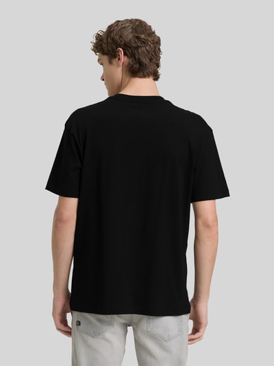 Männermodel trägt Relaxed Fit T-Shirt aus reiner Baumwolle von Tom Tailor Denim in Optik: Unifarben, Ganzkörperansicht Rückansicht.