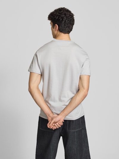 Männermodel trägt Regular Fit T-Shirt aus reiner Baumwolle von Tommy Jeans, unifarben, Rundhals, kurzarm, Jersey, Ganzkörperansicht Rückansicht.