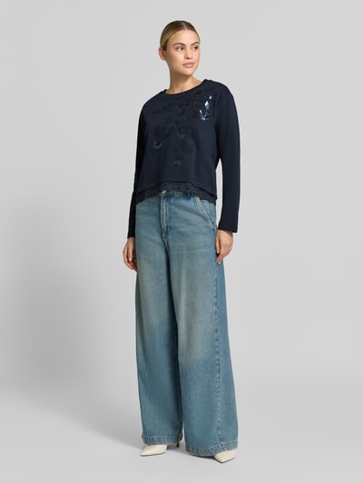 Frauenmodel trägt Regular Fit Longsleeve aus Baumwoll-Mix mit Spitzenbesatz von Milano Italy, florales Design, Pailetten, Dunkelblau, Ganzkörperansicht von vorne.