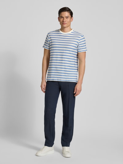 Männermodel trägt Herren T-Shirt mit Streifenmuster Modell 'MARINA' von Guess aus reiner Baumwolle, Regular-Fit, Rundhalsausschnitt, Ganzkörperansicht von vorne.