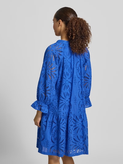Frauenmodel trägt Relaxed Fit Kleid in Knielänge mit floralem Allover-Lochstitching von Betty Barclay in leuchtendem Blau, reine Baumwolle, Tunika-Ausschnitt, 3/4-Arm, florale Musterstruktur, Ganzkörperansicht Rückansicht.
