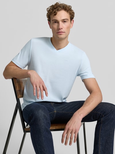Männermodel trägt Regular Fit T-Shirt aus reiner Baumwolle von s.Oliver RED LABEL in Hellblau mit glatter Textur, Nahaufnahme Oberkörper.