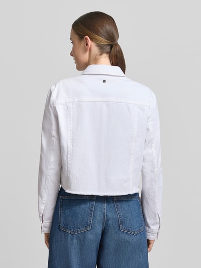 Männermodel trägt Jeansjacke mit Brusttasche und Fransen von Marc Cain, bawełna z domieszką elastanu, krój slim fit, biała, dżins, frędzle, szerokość w rozmiarze 36: 39 cm, długość pleców: 47 cm, szerokość biustu: 37 cm, długość rękawa: 59 cm, widok całej sylwetki z tyłu
