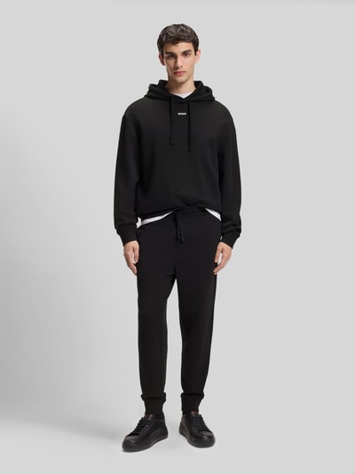 Männermodel trägt Regular Fit Jogginghose aus reiner Baumwolle Modell 'DAYOTE232' von HUGO, unifarben, Sweatstoff, Ganzkörperansicht von vorne.