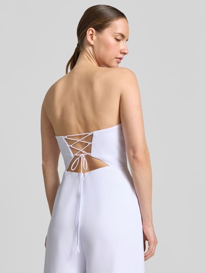 Frauenmodel trägt Jumpsuit mit Schnürung von Laona in Weiß, taillierte Passform, Ärmelloses-Design, Rückenansicht, Detailaufnahme. Rückenlänge 15 cm, Brustweite 29 cm, Gesamtlänge 134 cm, Innenbeinlänge 87 cm. Drapierungen und Reißverschluss auf der Rückseite sichtbar.