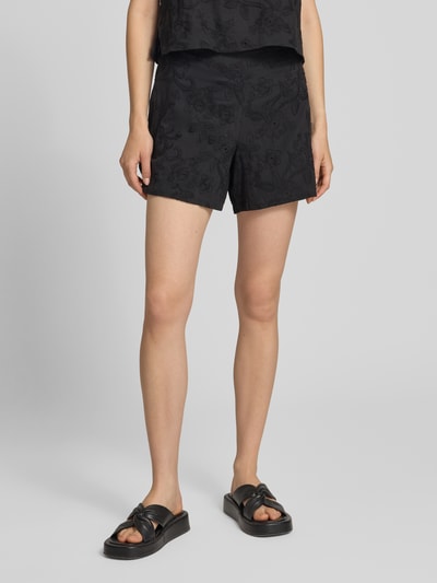 Kobiece model prezentuje czarne szorty z bawełny Regular Fit model 'PCGINGER' od PIECES, damskie szorty materiałowe, zdjęcie z przodu do połowy ciała.