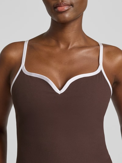 Frauenmodel trägt Trägertop mit Kontraststreifen Modell 'Sense Contour' von aim'n in Braun mit Weiß, körpernah, Nahaufnahme Oberkörper.